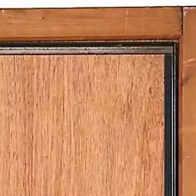 Cornière anti-pince fixée sur le chant d’une porte pour renforcer la sécurité