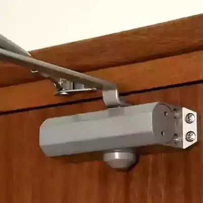 Ferme-porte hydraulique monté en applique sur porte en bois