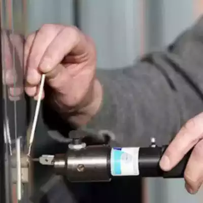 Serrurier utilisant un outil pour dégripper une serrure bloquée