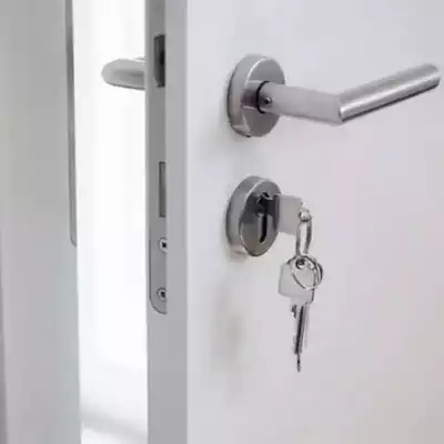 Clé insérée dans une serrure classique de porte intérieure blanche